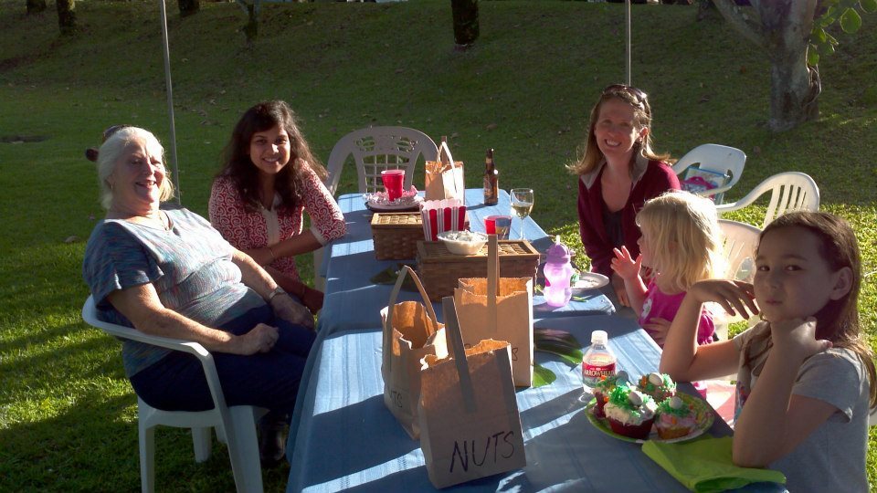 Photo Of Alum With Host Family Sitting Around A Table Eating