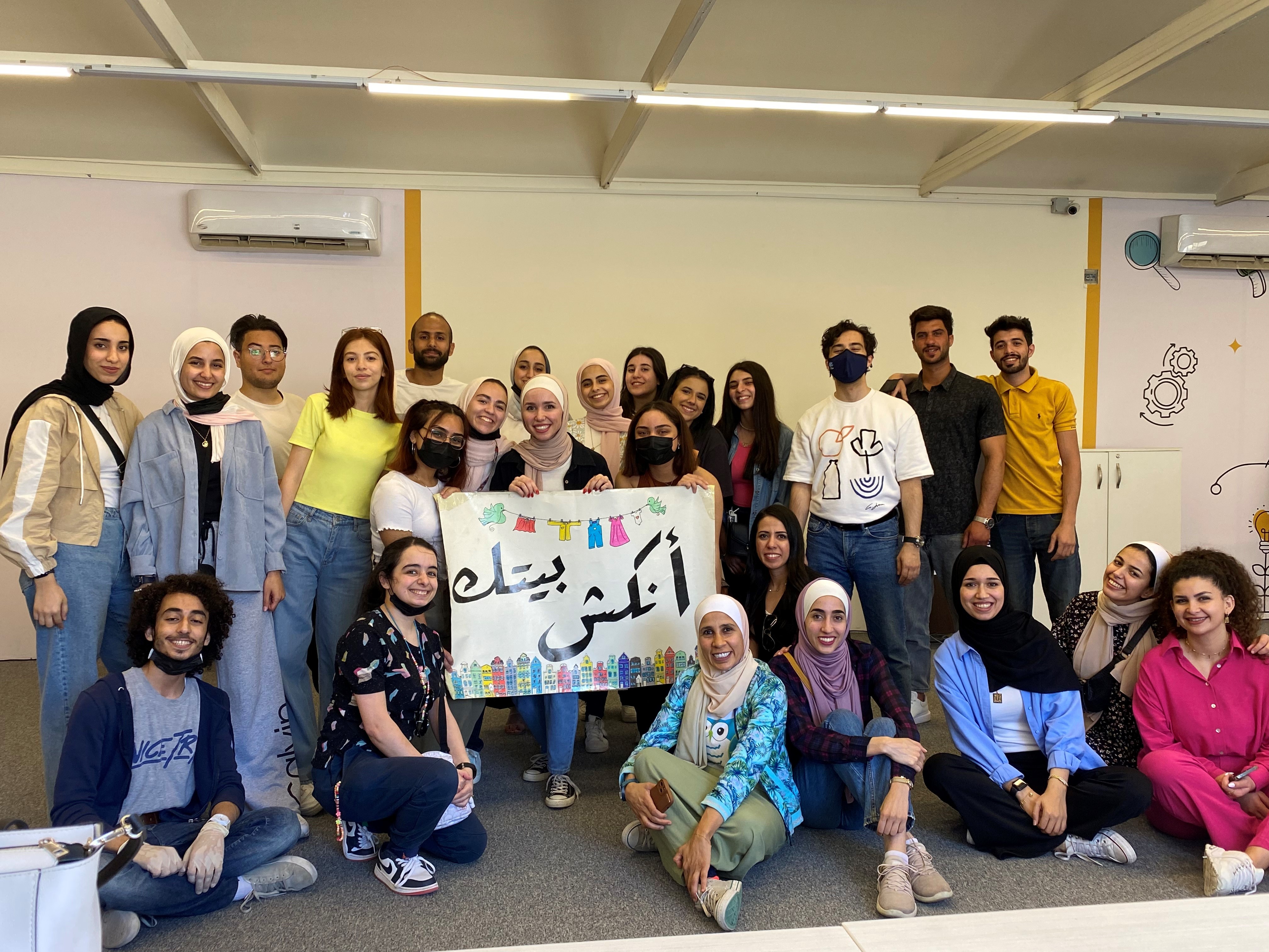 Group photo with Jordanian alumni holding a banner