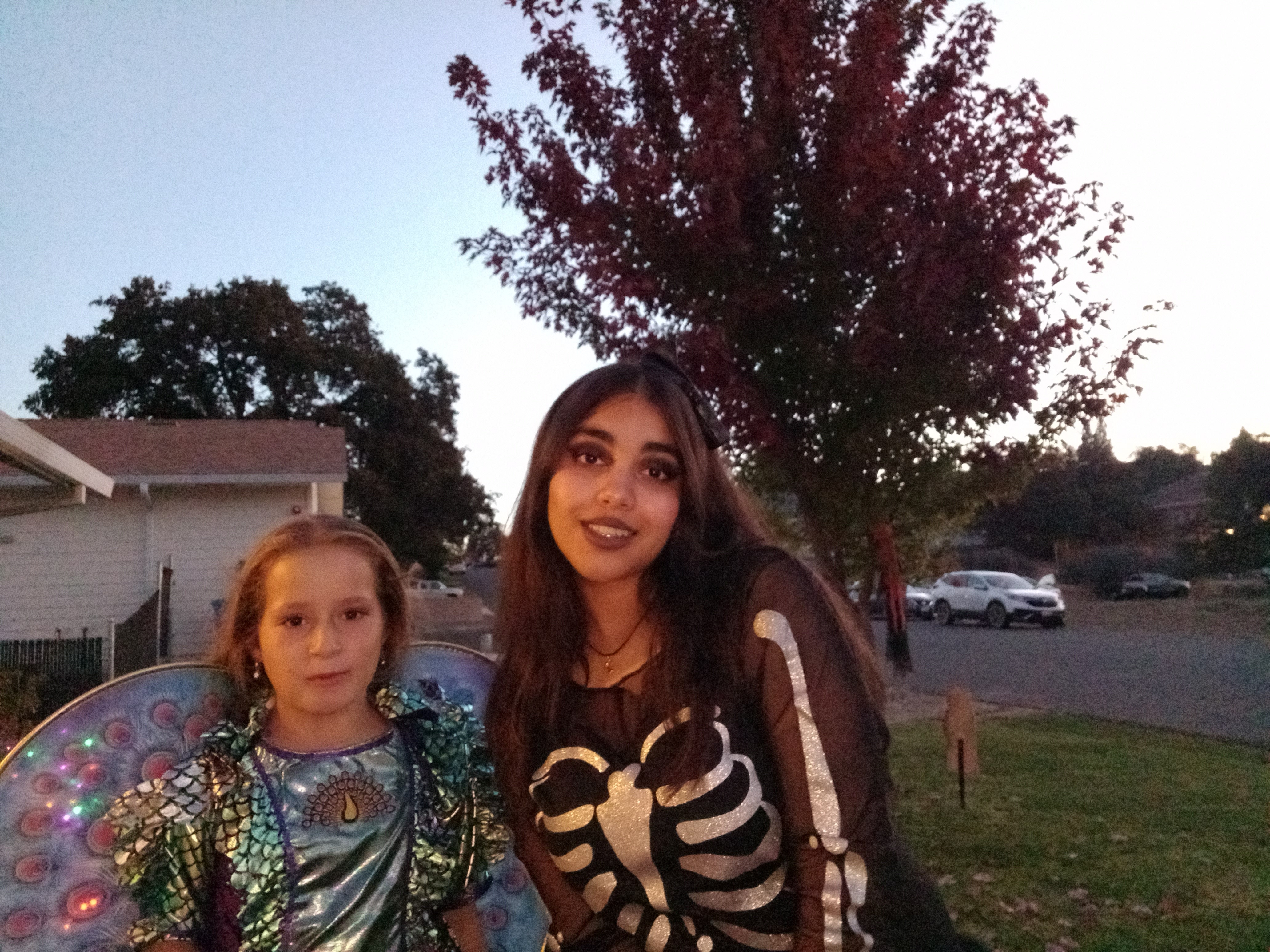 YES student standing next to host sister dressed up as a skeleton on Halloween.