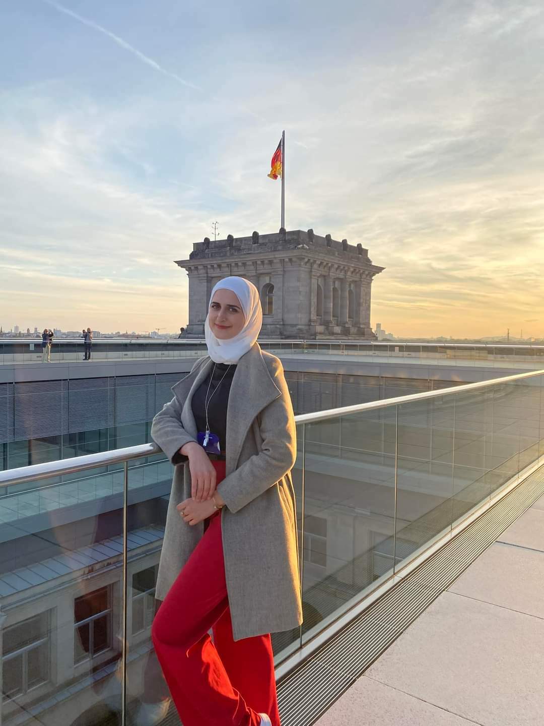 Female student Saba poses in front of a German flag on the roof of German Parliament