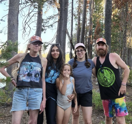 Rida and her host family standing together in a forest.