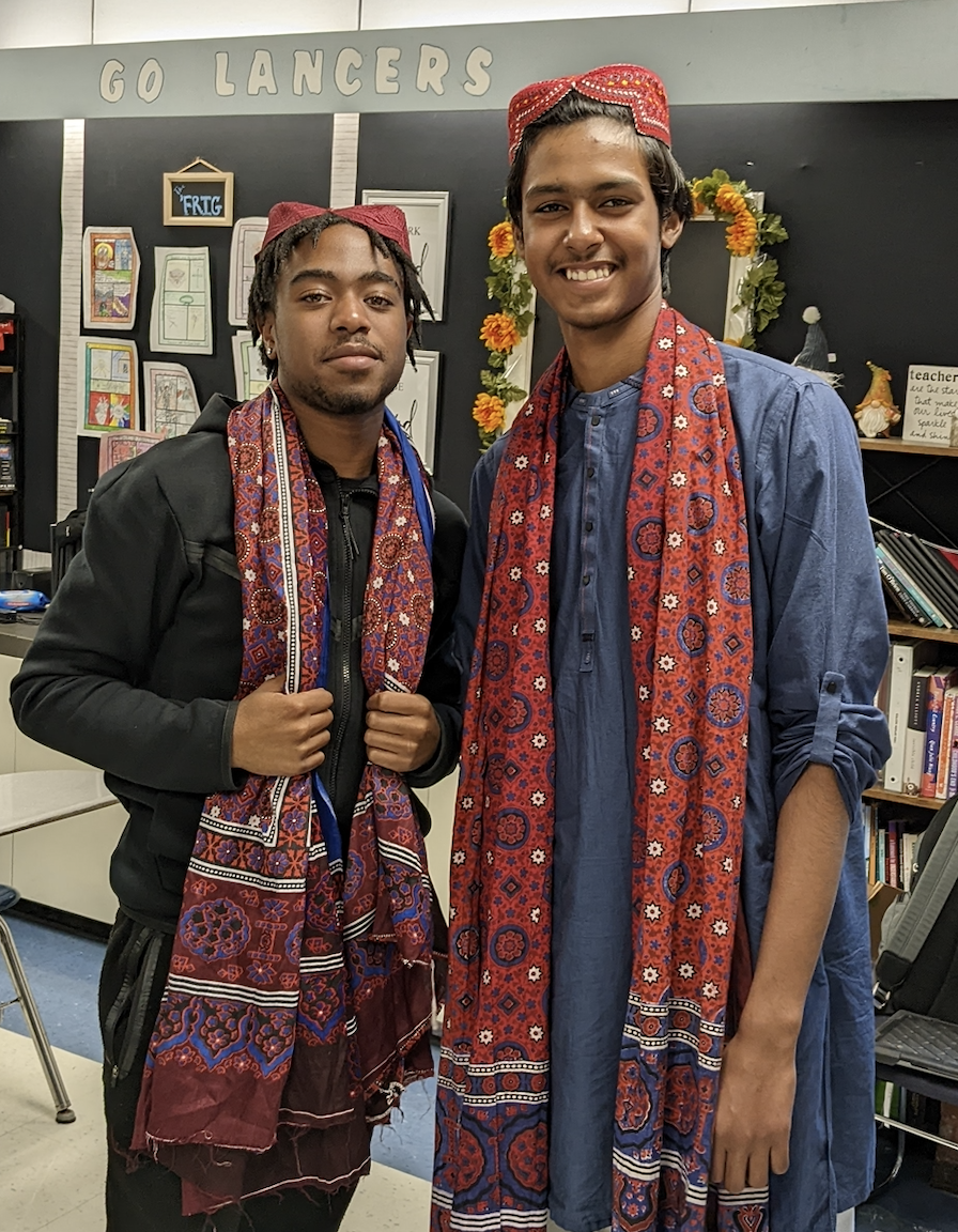 Rehan wearing traditional clothing and standing with a classmate.