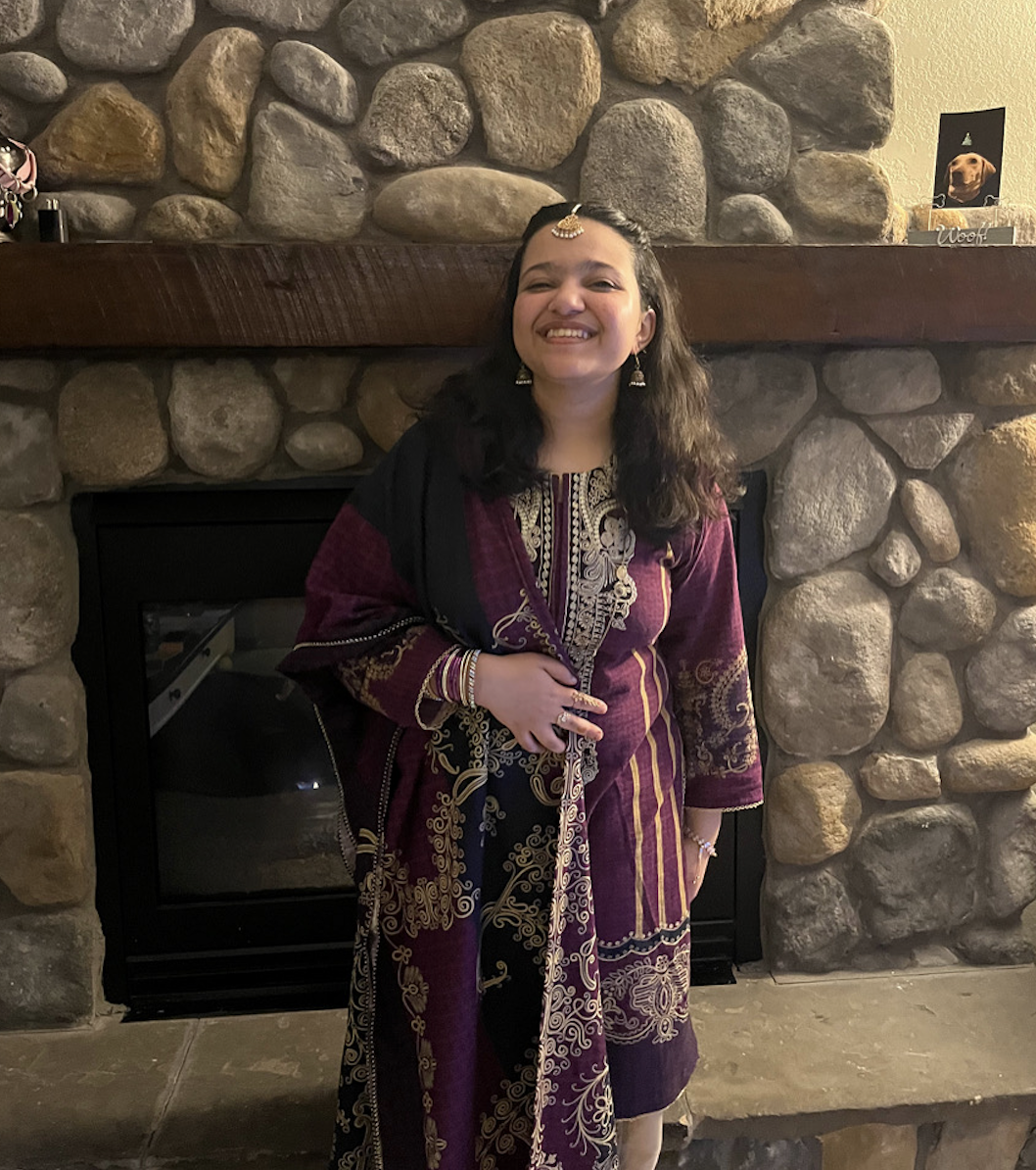 Student Posing In Front Of Fireplace In Traditional Clothing