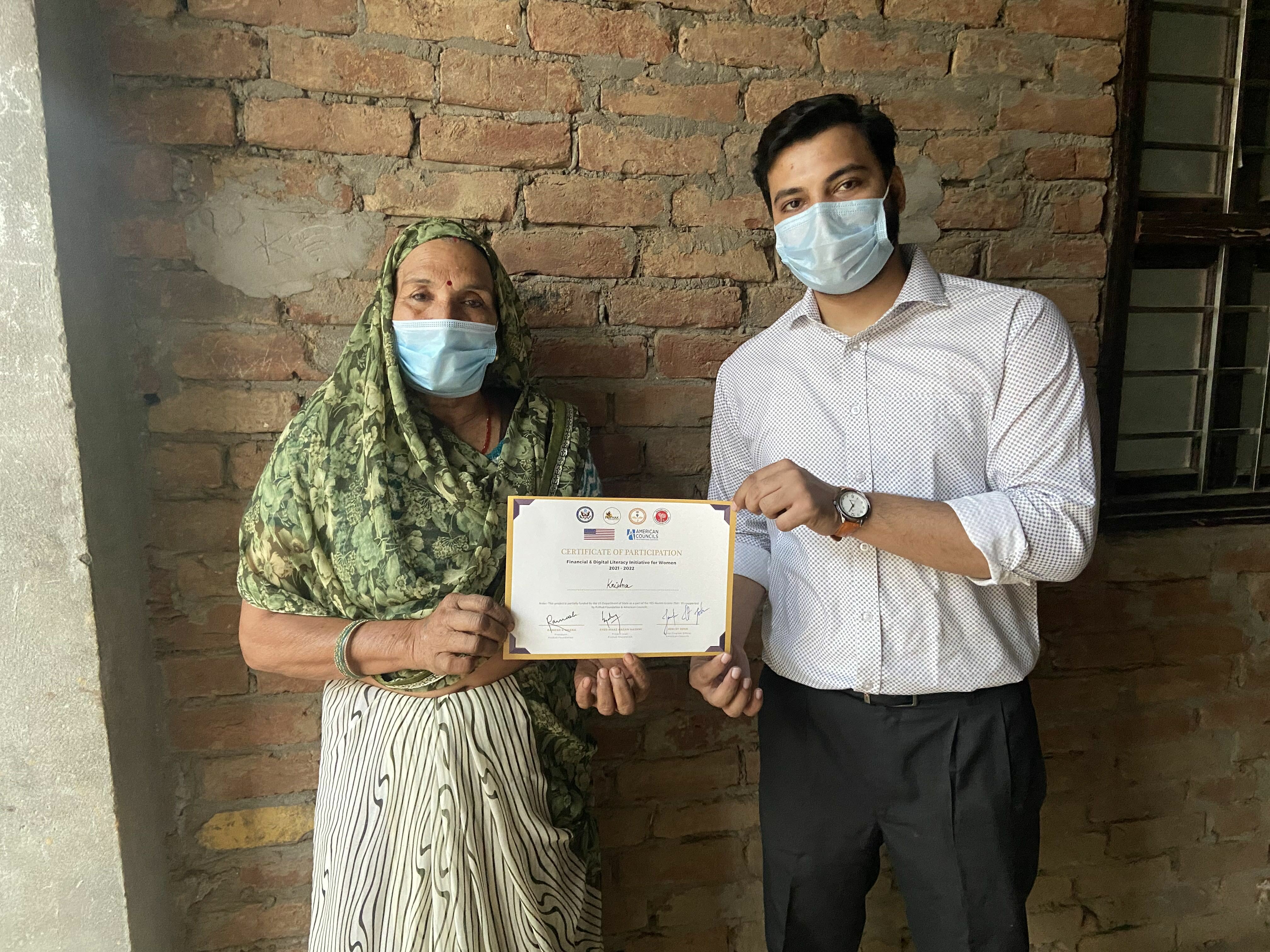 Syed Is Posing With A Participant While Handing Her A Certificate