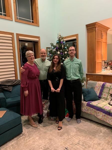 Imge with her host parents in front of a Christmas tree