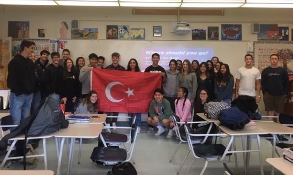 Verda holding Turkish flag with group of students in their Spanish class