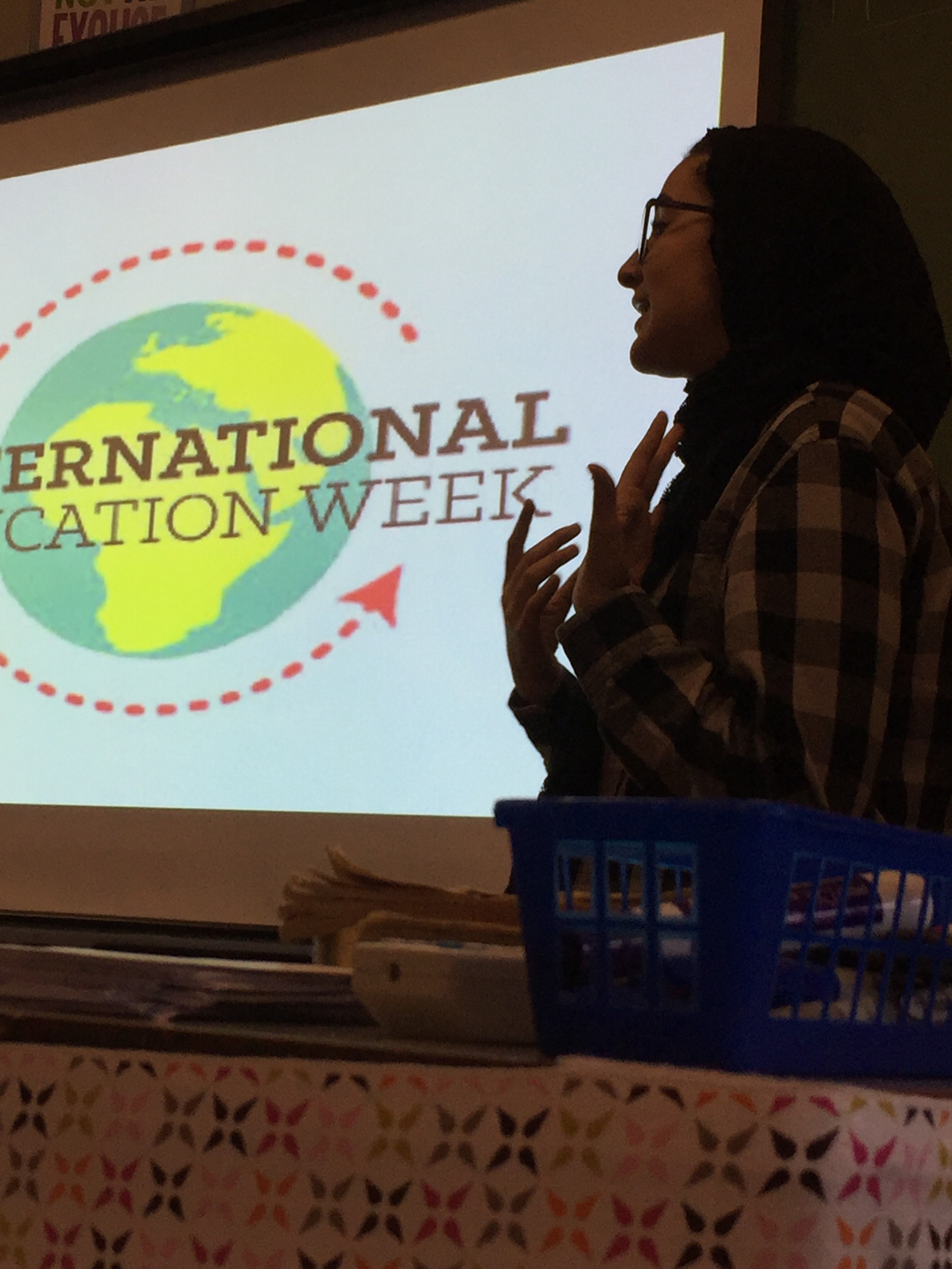 Taif standing in front of a projector and giving a presentation for International Education Week. 