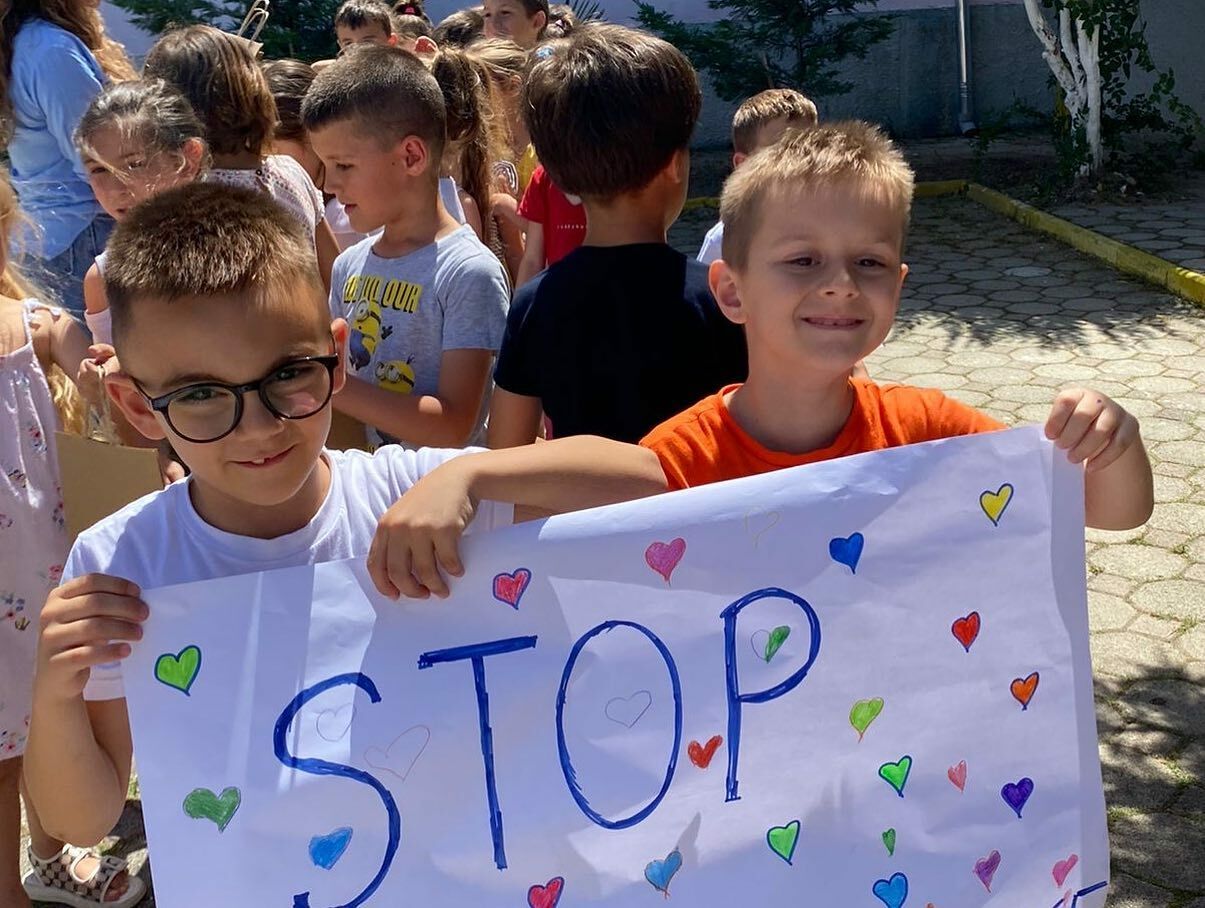 Two Children In Albania Hold A Sign Encouraging The Public To Stop Single Use Plastic Use