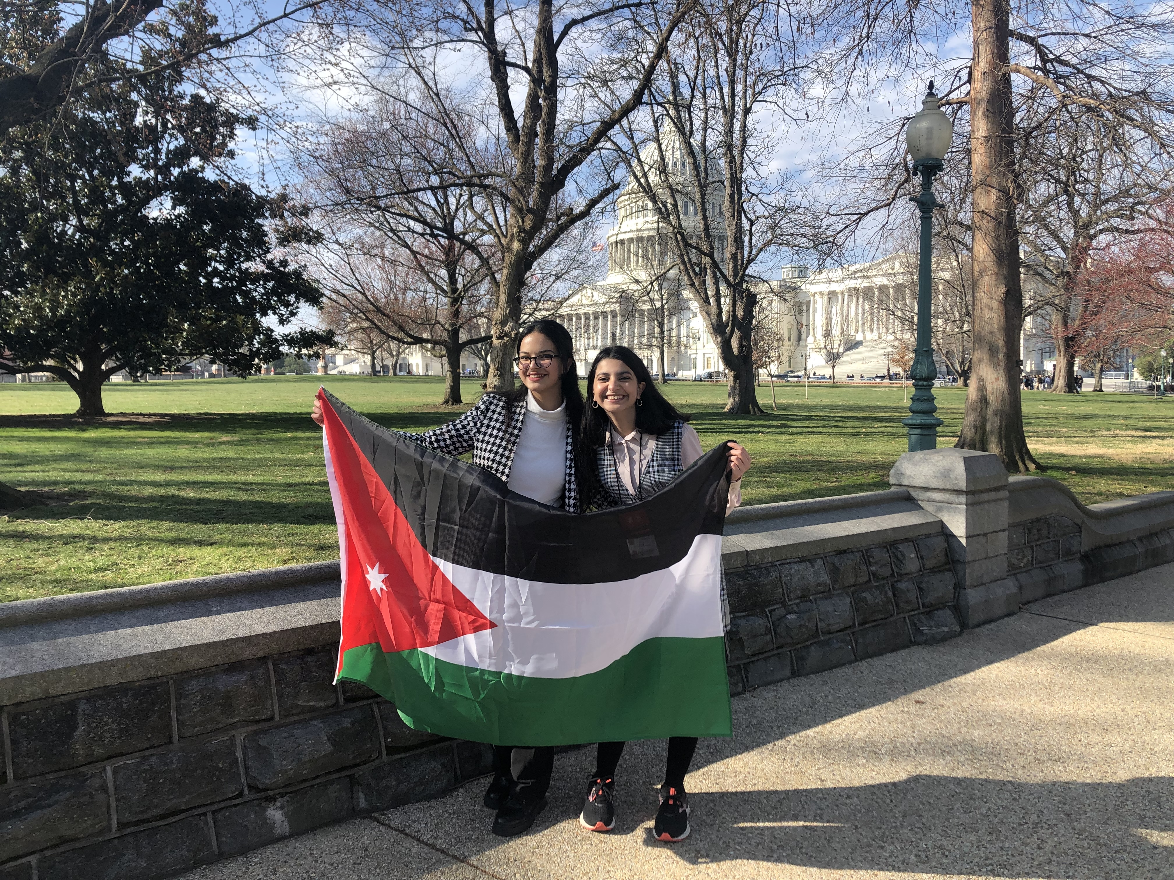 Two Young Women Holding The Jordanian Flag In Front Of The U S  Capitol