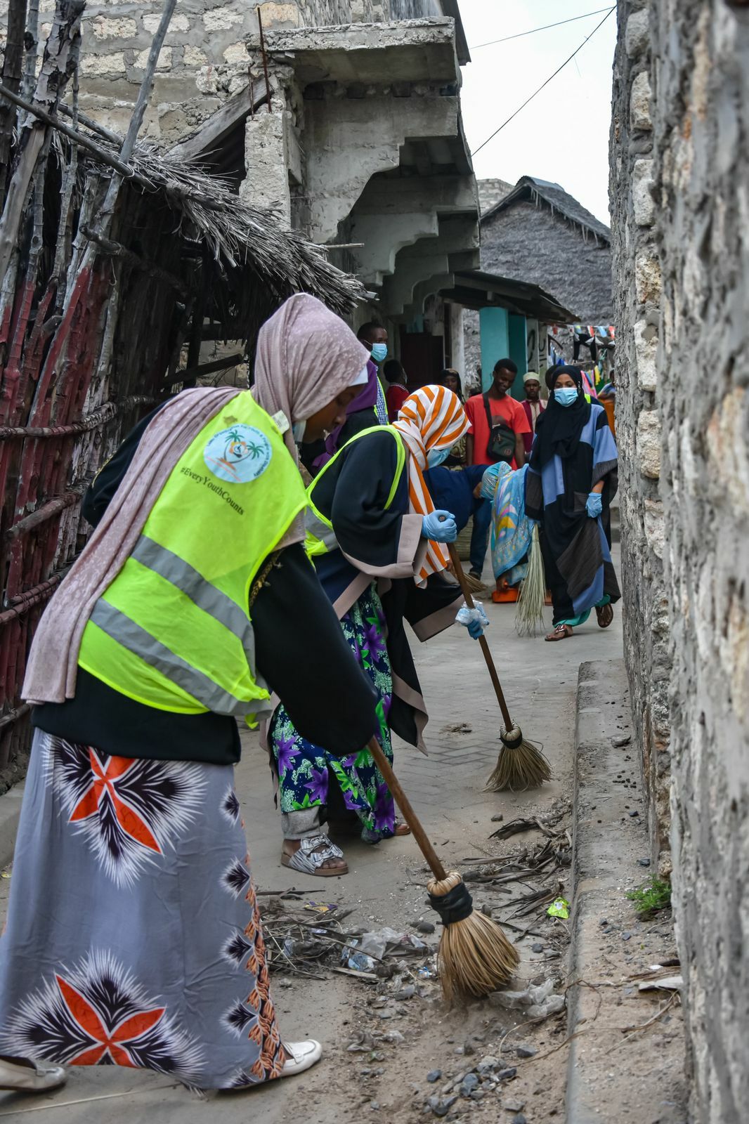 Volunteers swiping the street with brooms on a clean up action