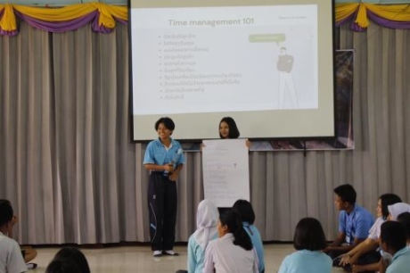 Two alumni giving a presentation at the front of the classroom about Time Management. 