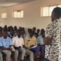 Fred Maina project leader doing a presentation on quality education while participants are seated in front of him
