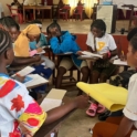 Participants gather in small groups during a breakout session actively discussing and taking notes as part of the training workshop in Bomi and Grand Cape Mount Counties