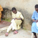 Three men deeply focused on preparing fabrics They sit outdoors working independently
