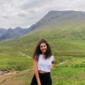 YES alumna, Natali, standing in front of green mountains.
