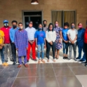 A group of ten Liberian students standing outside with masks on