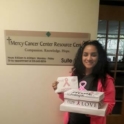 A YES alum standing infront of a sign that reads "Mercy Cancer Center Resource Center"