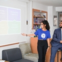 Young woman gestures to a project powerpoint with a young man standing next to her