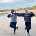 Two boys smiling and standing on one leg