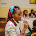 Tasha stands at a YES workshop speaking through a microphone