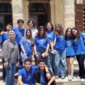A group of alumni standing on stairs in blue t shirts