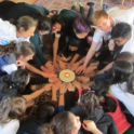 A Group Of Students Putting Their Hands In The Middle Of A Circle
