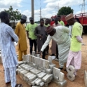 A Group Stands Around An Interlocking Tile Project Done By A Participant During The Final Exhibition And Closing Ceremony