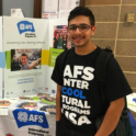 YES student, Mudda, standing in front of an AFS poster.