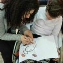 An alum draws with a child