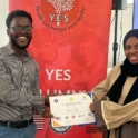 Alex Mwakilau Is Presenting A Certificate To A Participant In Front A Yes Banner