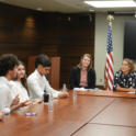 Alumni sitting around a table with the Ambassador