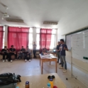 An alum presenting at the front of a classroom of boys