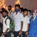 Large groups of students participating in an American holiday event in Bangladesh. Some students are wearing clown masks.
