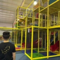 A student looks at a jungle gym in an adventure park for kids