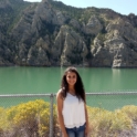 Dalya standing in front of a river and cliffs