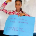Deborah holds a sign that says, "empower girls through education"