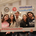 Five Alumni Holding A Cardboard Photo Frame With Yesalumni Jordan And Yes Logos