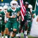 YES student, Omari, running on the football field with a group of football players