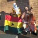 YES student, Samira, holding the Ghanian flag and standing next to someone playing the cello.