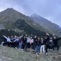 Global Village Participants Standing On A Mountain In Hiking Gear