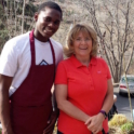 Godwill wearing an apron and standing next to his host mom