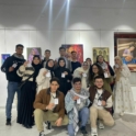 Group of organizers holding their name tags in front of paintings