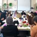 Group of women seated on a table knitting together