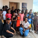 Group photo of the two YES alumni with the scholars who came to view their new library on the reveal day