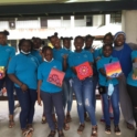 Surinamese alumni and participants wear blue shirts and hold their paintings