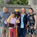 Student posing with host family at graduation