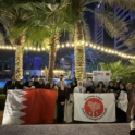 Large group of alumni holding the KL-YES and Bahraini flags