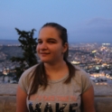 Stanimira from Bulgaria stands above a viewpoint. It is dusk and the town behind her is lit up with lights.