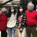 YES student, Felicia, standing with her host family at the airport. All four people are wearing masks.
