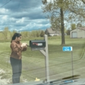 Islem depositing a thank you card into a mailbox